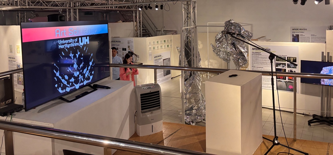 A room showing art installations with screens, information boards and metal structures